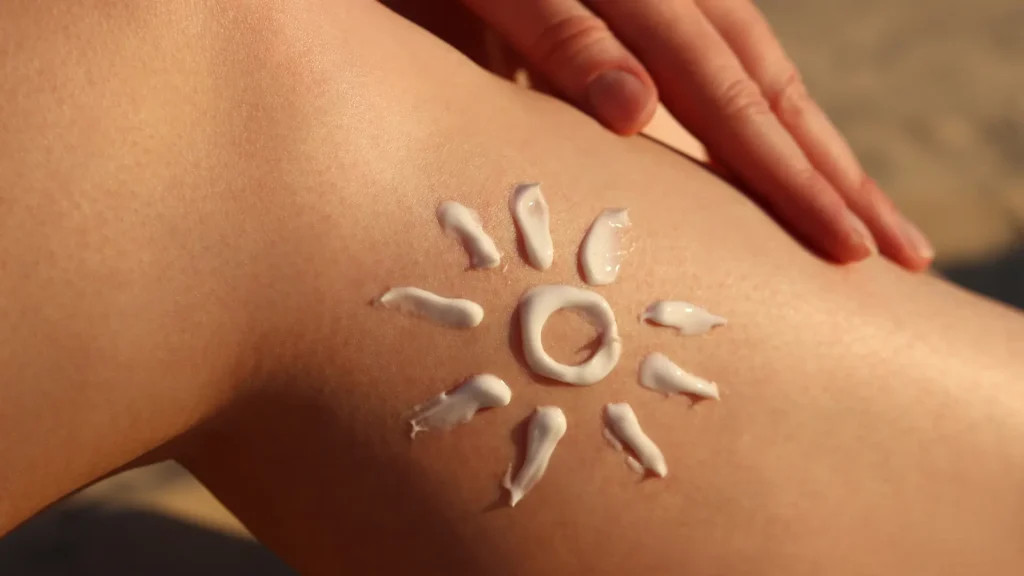 an image of a person's leg with a drawing of a sun using lotion for a blog post about sun damaged skin